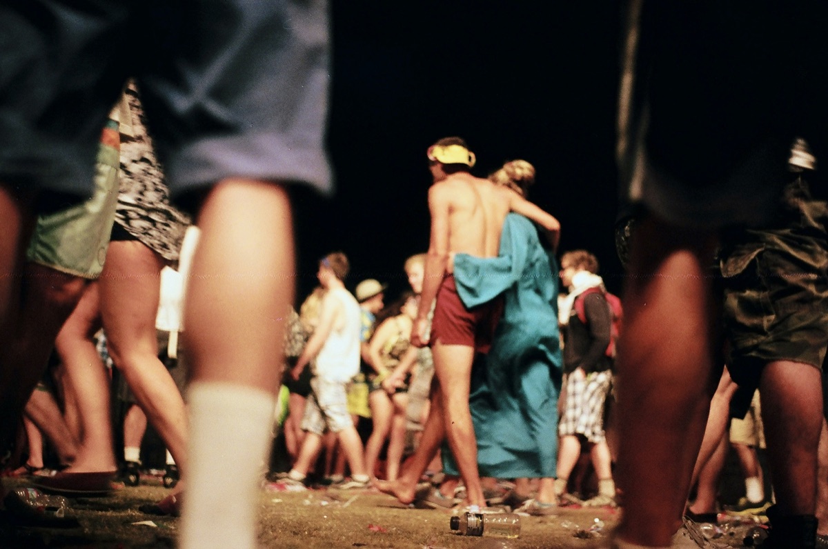 Festival crowd walking through outdoor event grounds at night