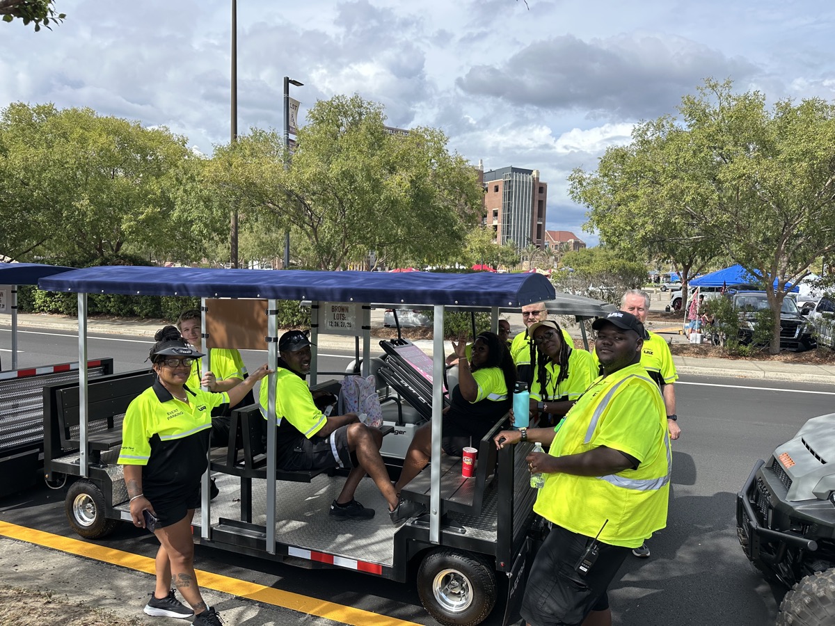 Crew in safety vests riding FlexTram shuttle to job site