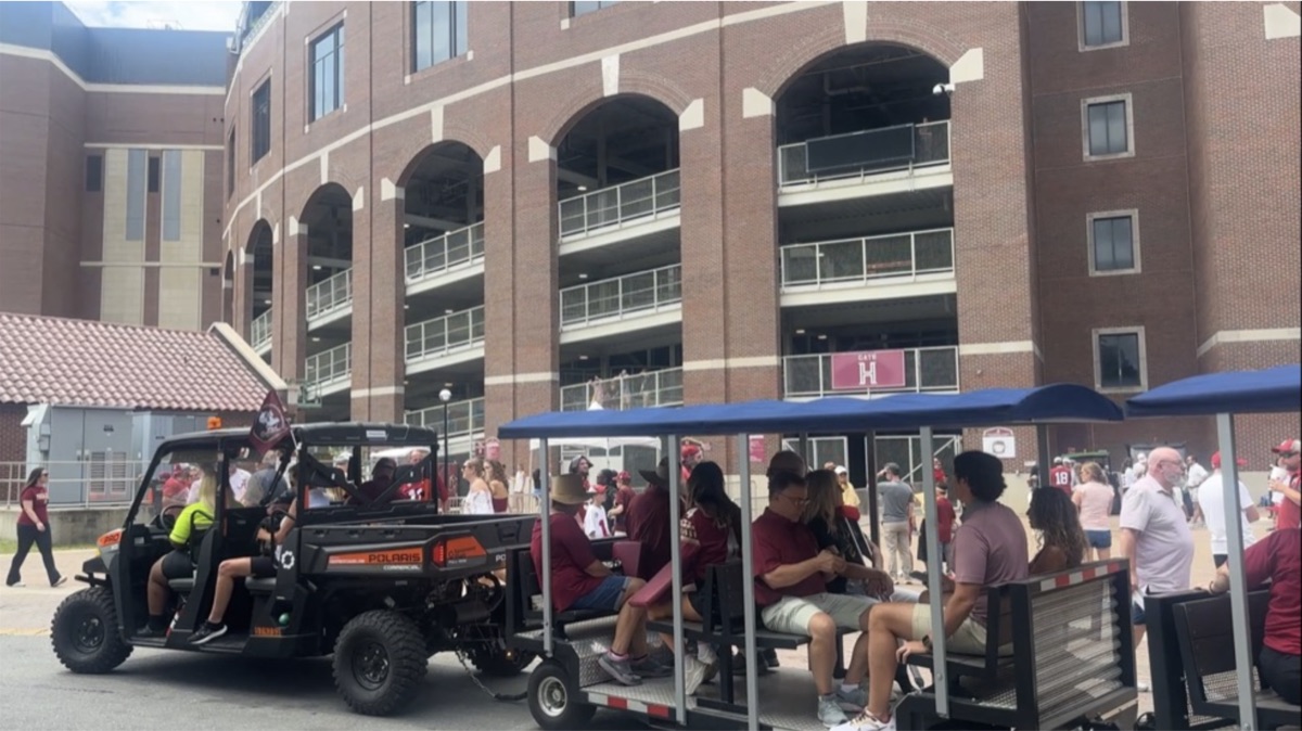 FlexTram tram full of passengers at university stadium on game day