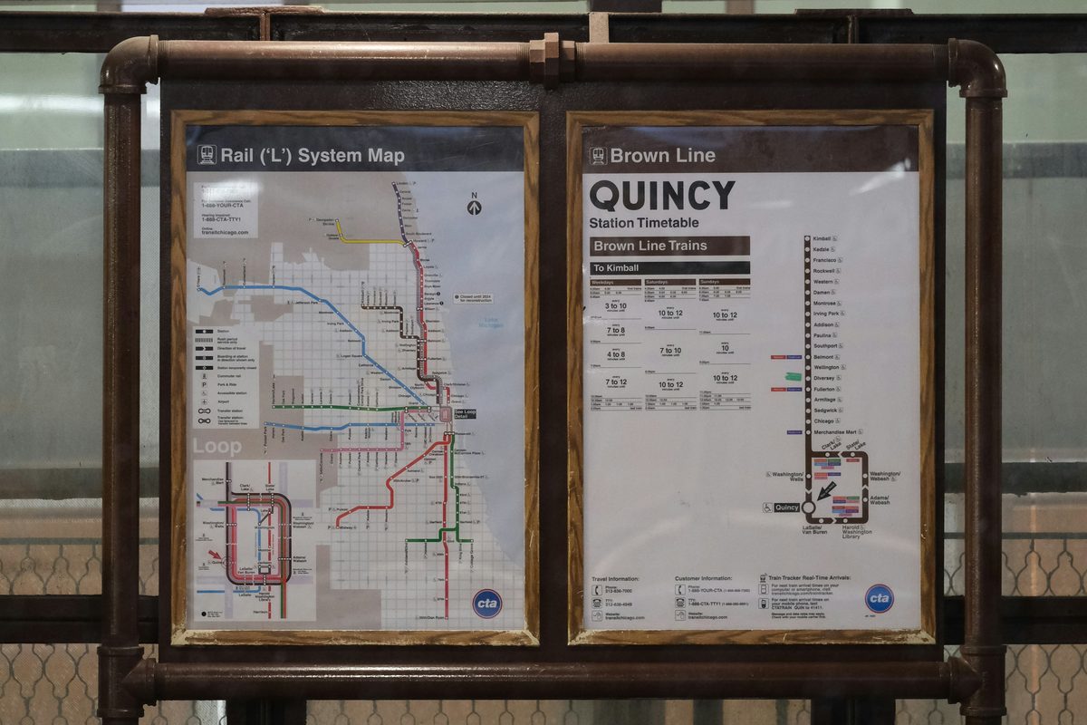 A Chicago CTA station board mounted on a rusted pipe frame displaying the Rail L System Map beside the Brown Line Quincy station timetable with posted train frequencies