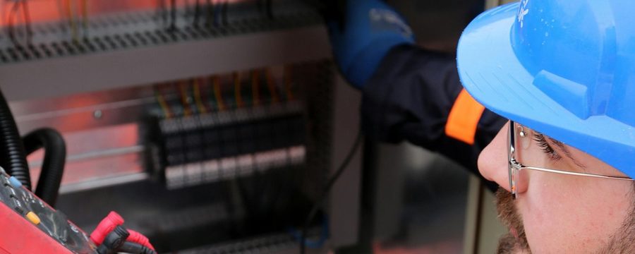 Technician working on an electrical control panel at a data center site