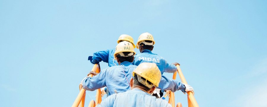 Construction workers on scaffolding with hard hats