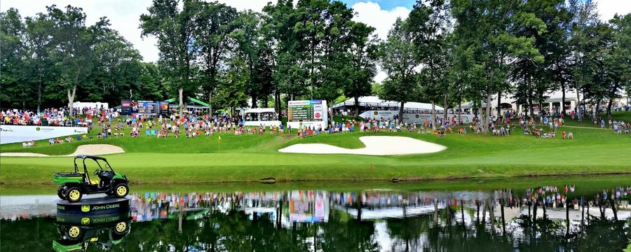 Golf tournament gallery around a green with spectators lining the fairway
